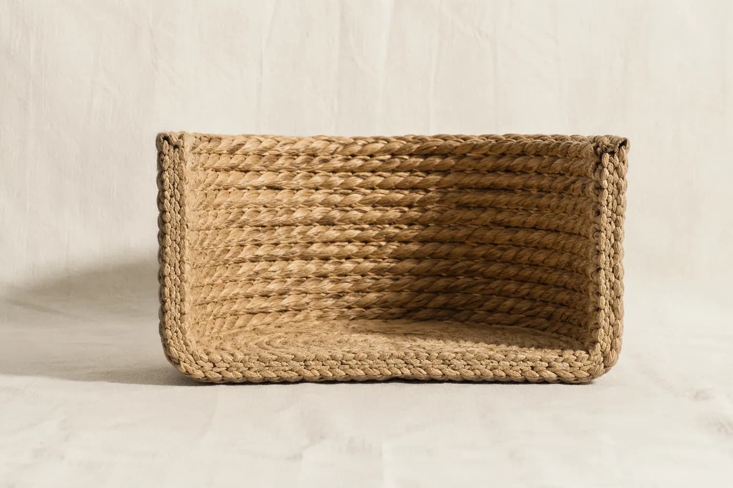 A round basket cut vertically in half showing the thickness of the woven wall and the hollow interior.